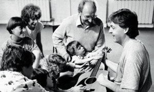 Clive Robbins, en el centro, con Paul McCartney, ayudando a los niños a aprender a través de la música.