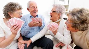 A group of happy elderly people enjoying themselves over a card game